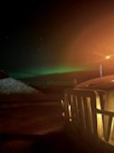 Northern lights in the night sky behind a truck